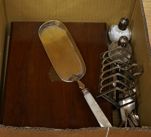 A cased set of twelve pairs of mother of pearl handled plated dessert eaters and a quantity of assorted plated items including a toastrack, a pair of mounted glass condiments, crumb scoop and miscellaneous flatware.